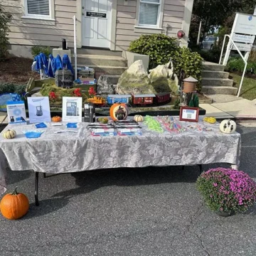 Outdoor booth with pumpkins, crafts, and promotional materials for event